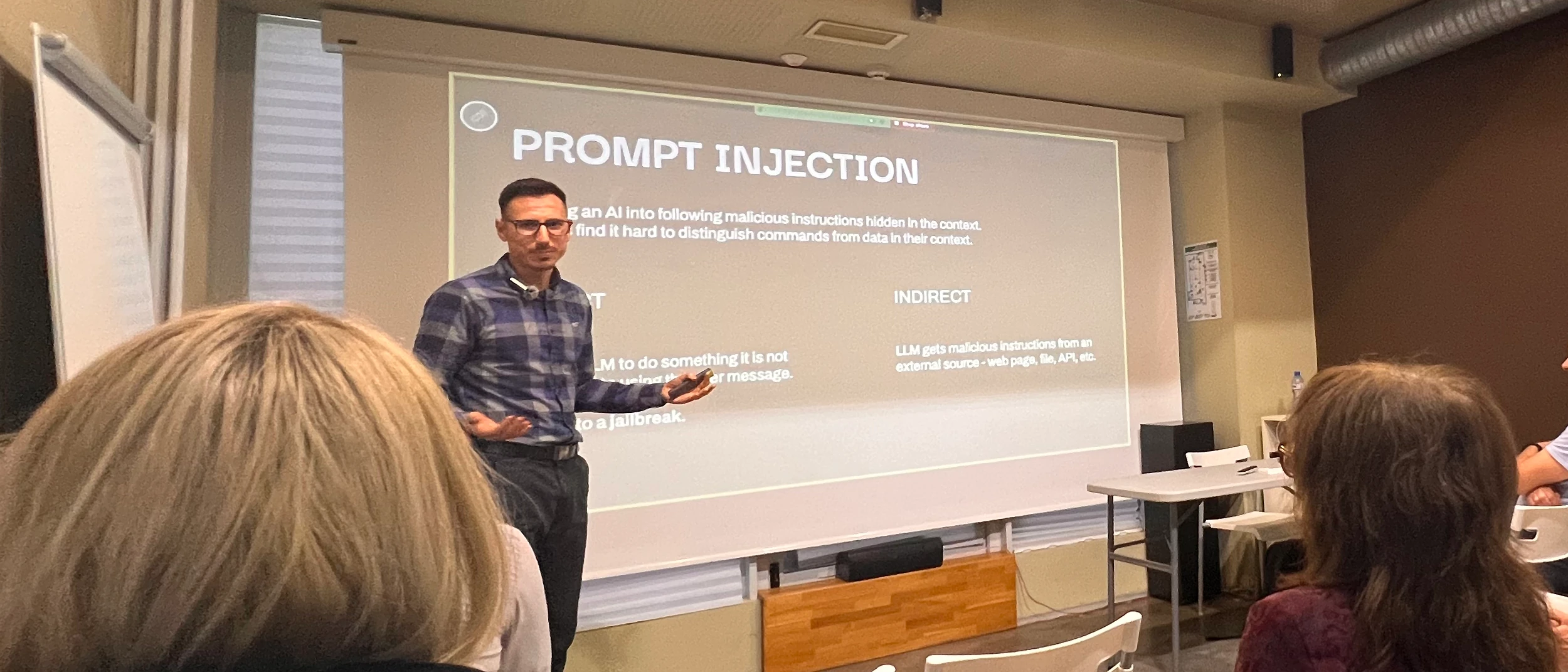 Stihia presenter explaining prompt injection to the audience at an AI security workshop